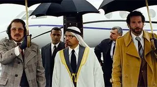 Irving Rosenfeld (Christian Bale) i agent FBI Richie DiMaso (Bradley Cooper) w towarzystwie nieistniejącego szejka (Michael Peña)