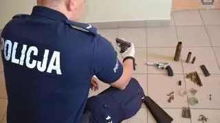 Kobieta miala w domu rewolwery, pistolety i amunicję
