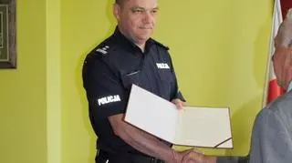 Komendant powiatowy policji w Jarosławiu wręcza list od szefa MSWiA odważnemu mężczyźnie 