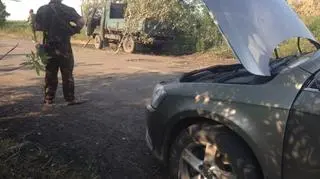 Na drugim planie za samochodem zamaskowane gałęziami działko przeciwlotnicze