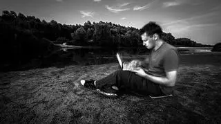 Oczekując na ptaki w błocie wiślanej wyspy, Łukasz Bożycki pracuje nad kolejnym rozdziałem książki "Animal Rationale"