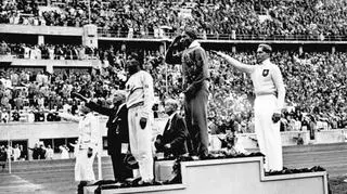 Owens na podium w Berlinie w 1936 r. po zwycięstwie w skoku w dal. Trzeci Naoto Tajima z Japonii, drugi Lutz Long