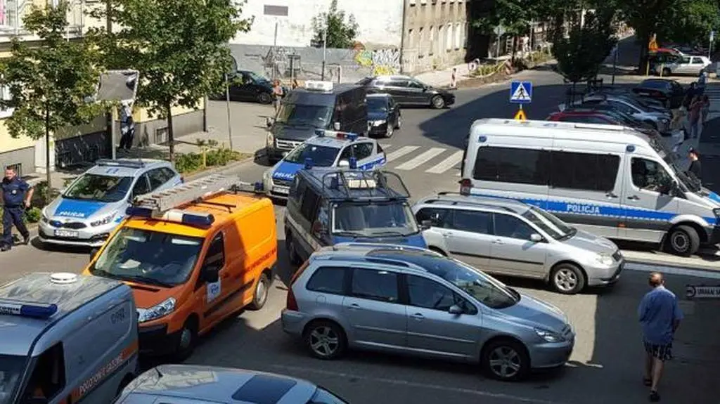 Pod budynkiem stoją radiowozy