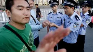 Policjant w cywilu zabrania fotografowania  placu (PAP/EPA).