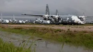 Rzędy transportowców C-130 Hercules gotowych na ewentualne przywrócenie do służby. Zdjęcie wykonane po bardzo rzadkim zjawisku w tym miejscu - ulewie