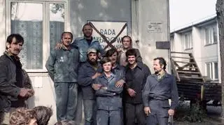 Strajkujący pod tablicą z przekreśloną nazwą Rada Zakładowa