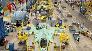 Szereg F-35 podczas końcowego montażu przed opuszczeniem hali. Widać między innymi zamontowane już stateczniki poziomie i pionowe na ogonie (duże szare powierzchnie z tyłu maszyny)