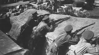 Szwoleżerowie podczas strzelania z karabinów w okopach na jednej z ulic Warszawy