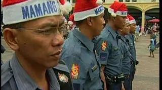 Ze świętym Mikołajem łączy ich tylko czerwona czapka, ale ich widok wywołuje równie dużo uśmiechów i sympatii. Chyba nikt nie domyśliłby się, że chodzi o .... policjantów. (APTN)