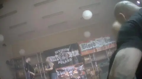 Kadr z reportażu Superwizjera. Za sceną widać banery o tematyce nazistowskiej