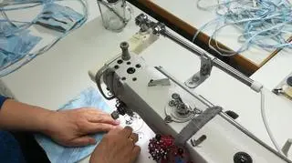 Ludzie szyją maseczki na maszynach