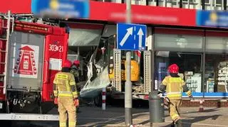 Przyczepa z koparką wjechała w witrynę apteki