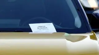 Za wycieraczkę włożono kartkę informującą o zablokowanym kole