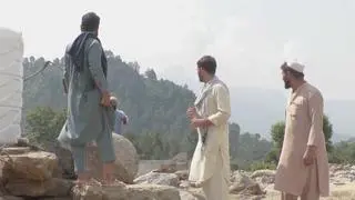Noor Muhammed z członkami swojej rodziny obok ruin domu