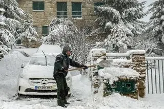 Mężczyzna odgarniający śnieg w wiosce Penhas da Saude w Portugalii