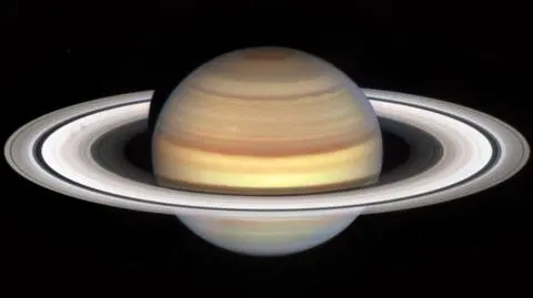 Saturn w obiektywie teleskopu Hubble'a. Z lewej strony widoczne są dwie ciemniejsze "szprychy" na pierścieniu B