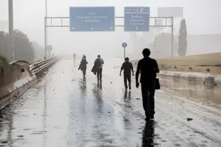 Mieszkańcy idą pokrytą błotem drogą w gminie Sedavi, prowincja Walencja