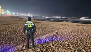 Funkcjonariusz policji patroluje plażę w mieście Gangneung w Korei Południowej po tym, jak wydano ostrzeżenie przed tsunami
