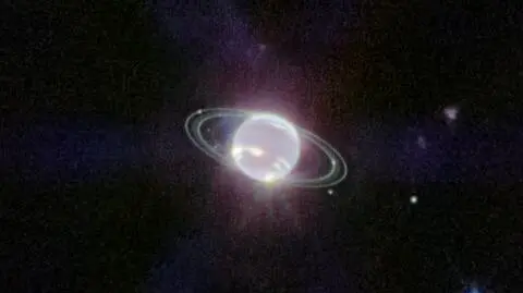 Zdjęcie wykonane przez teleskop Webba, na którym widać Neptuna, jego układ pierścieni i siedem księżyców