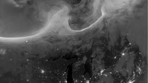 Zorza na tle miejskich świateł i poświaty niebieskiej