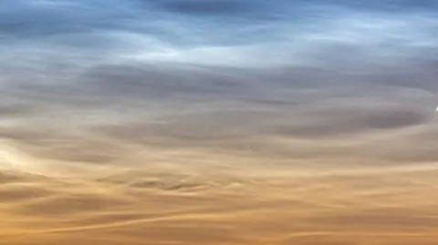 Kometa na tle obłoków srebrzystych