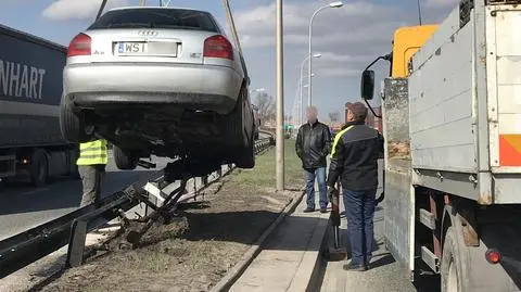 Auto w barierach, ściągał je podnośnik