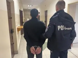 Policjant z zatrzymanym mężczyzną 