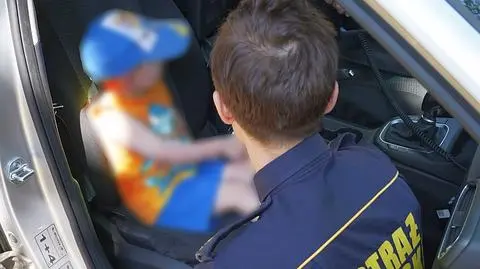 Mały chłopiec na rowerku biegowym jeździł obok autobusów
