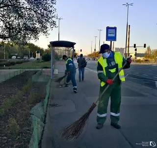 Służby porządkowe zamiatają chodnik  przystanku autobusowego