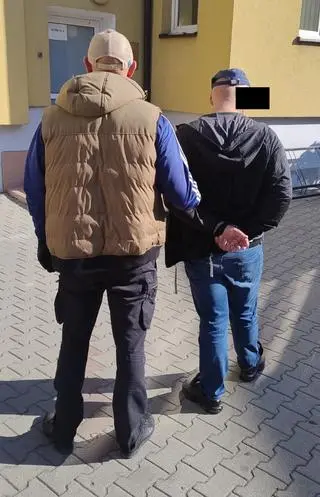 Policjant z zatrzymanym mężczyzną 