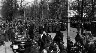 Tłumy obserwujące przybycie uczestników marszu oraz orkiestrę wojskową