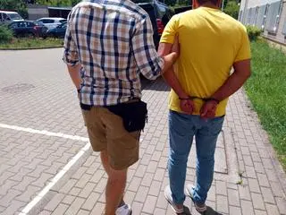 Policjant z zatrzymanym mężczyzną 