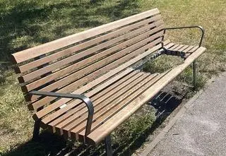 Ławka z wypaloną dziurą po grillu, gwoździe wbite w drzewo