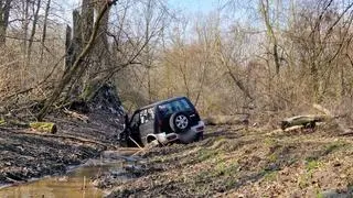 Zakopany pojazd terenowy w lesie na Targówku