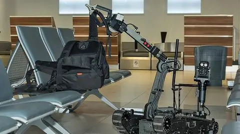 Robot pirotechniczny podnosi plecak 