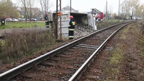 Ciężarówka na boku, gruz na torach