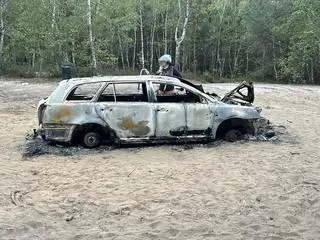 Spalony samochód w środku lasu