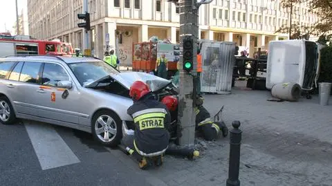 Wypadek w centrum. Śmieciarka na boku, taksówka na słupie