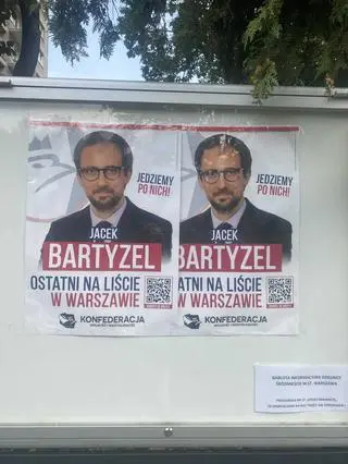 Plakaty wyborcze w gablocie na płocie przedszkola