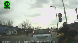 Auta stoją przed pasami, motocyklista przejeżdża
