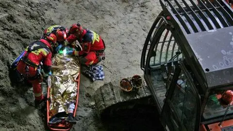 Mężczyzna pod koparką. Manewry na budowie metra