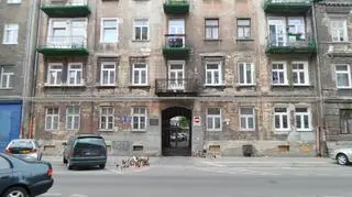 Kwiaty i znicze przed kamienicą