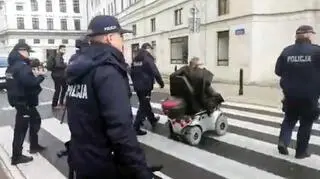 Policjanci prowadzą mężczyznę do toalety