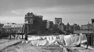 Kobieta wieszająca pranie, w tle Stare Miasto, 1946