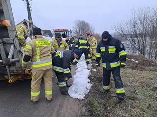 Strażacy układali worki z piaskiem