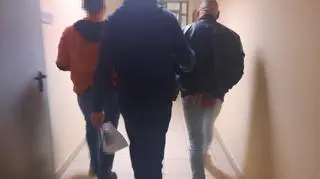 Policjant prowadzi zatrzymanego