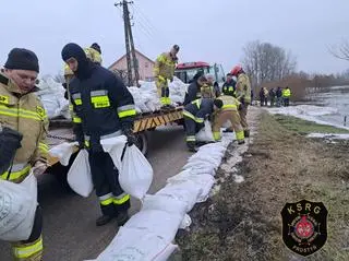 Strażacy układali worki z piaskiem