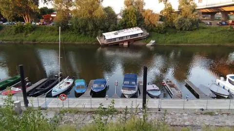 Porzucona barka zalega w porcie. Prowizoryczny płot też zostaje