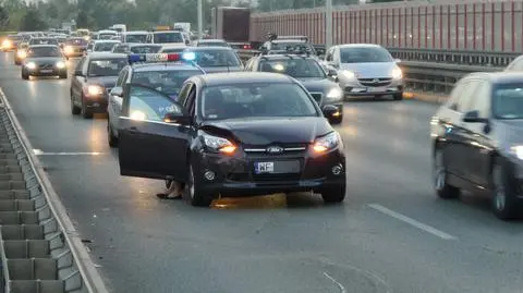 Trasa Siekierkowska w korku, auto na barierkach