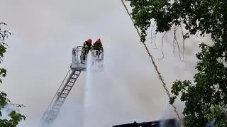 Strażacy gaszą ogień z podnośników 